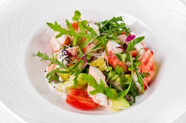 Üstten Görünüm salata karides, domates, peynir ve roket salata bir plaka üzerinde beyaz bir arka plan üzerinde kapat