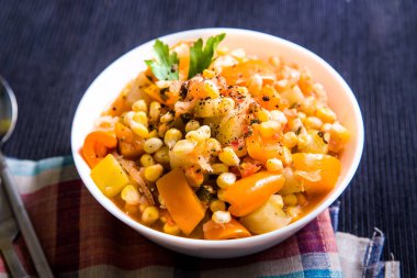 Mısır ile Sebze Güveç, tatlı biber, masada beyaz bir tabak kabak, üst görünüm