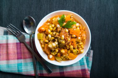 Mısır ile Sebze Güveç, tatlı biber, masada beyaz bir tabak kabak, üst görünüm