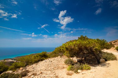 Kıyı şeridinin mavi gökyüzü altında yemyeşil bir bitki örtüsü, Kos Adası, Yunanistan