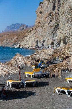 Nakış Therma, sıcak termal yayı, güneşli bir günde Yunanistan 'ın Kos adasında kayalıkları ve şemsiyeleri olan bir plaj.