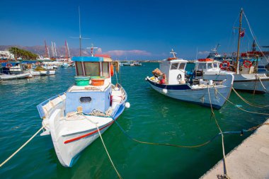 Güneşli bir günde, Yunanistan 'ın Kos adasında açık mavi gökyüzü olan bir limana yanaşan tekneler.