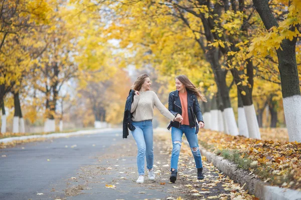 Genç güzel kızları sonbahar arka planda açık havada eğleniyor. Sonbahar zaman neşeli arkadaşlar