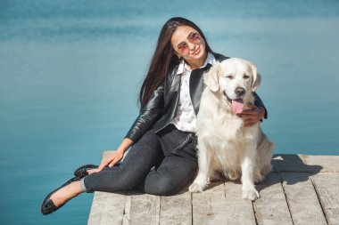 Genç çekici kadın köpeğiyle iskelede oturuyordu. En iyi arkadaşlar açık havada