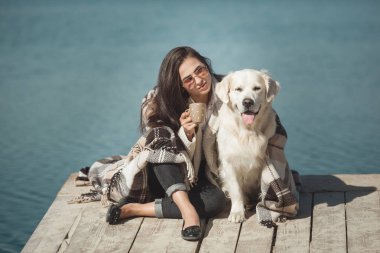 Genç çekici kadın köpeğiyle iskelede oturuyordu. En iyi arkadaşlar açık havada