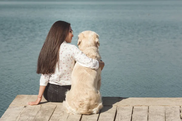 Genç çekici kadın köpeğiyle iskelede oturuyordu. En iyi arkadaşlar açık havada
