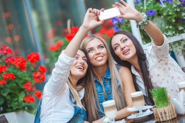 Grup selfie kafede yapma ve having fun çekici genç kadını
