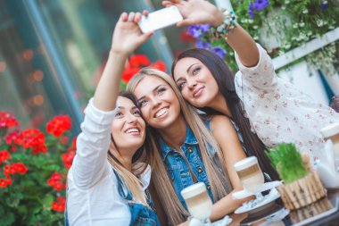Grup selfie kafede yapma ve having fun çekici genç kadını