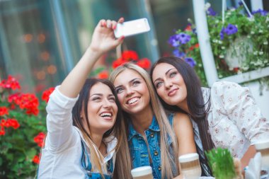 Grup selfie kafede yapma ve having fun çekici genç kadını