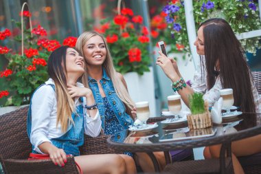 Grup selfie kafede yapma ve having fun çekici genç kadını