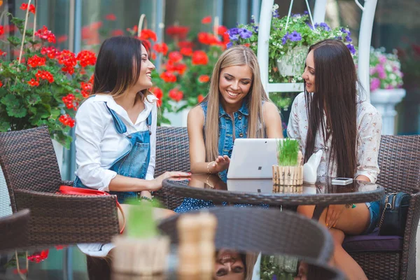 Grup Genç neşeli kadınların tablet vasıl seyir ve açık havada online alışveriş yapma