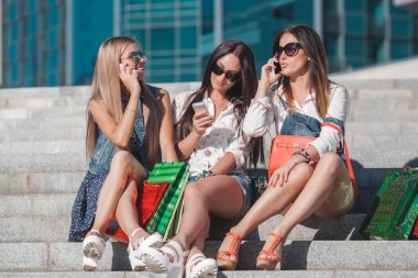 Genç güzel kızları selfie yapma ve açık havada eğleniyor. Bir cep telefonu üzerinde konuşurken kadınlar