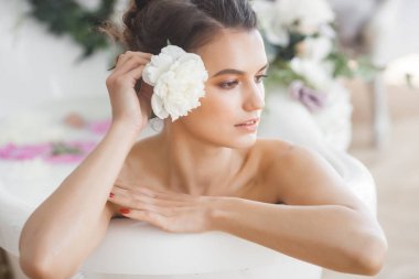 Genç güzel kadın alarak banyo çiçek ve süt ile