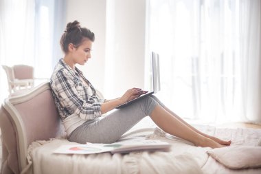 Genç çekici kadın çalışma dizüstü evde. Rahatlatıcı ve işten dinlenme kız