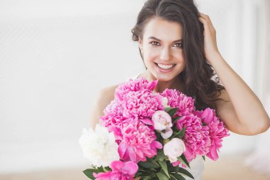 Pembe ve beyaz şakayık çiçekleri olan çekici kadın
