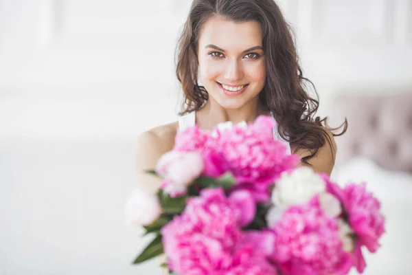 ピンクと白の牡丹の花を持つ若い魅力的な女性 — ストック写真