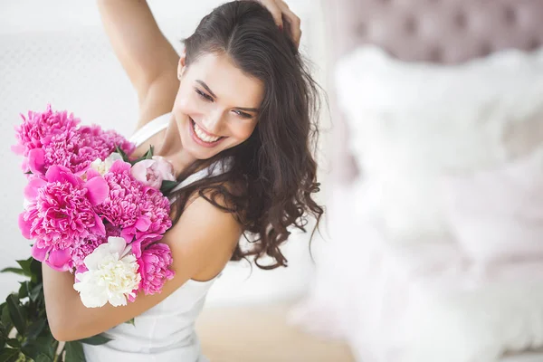 Young attractive woman with pink and white peony flowers