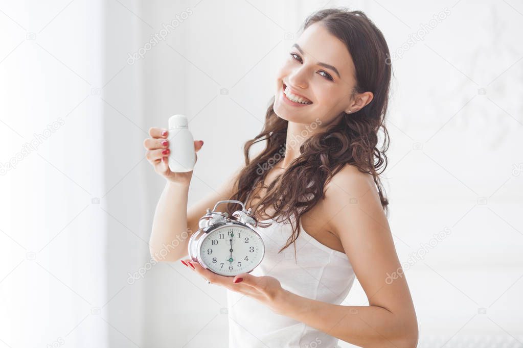 Young attractive woman taking pills at right time