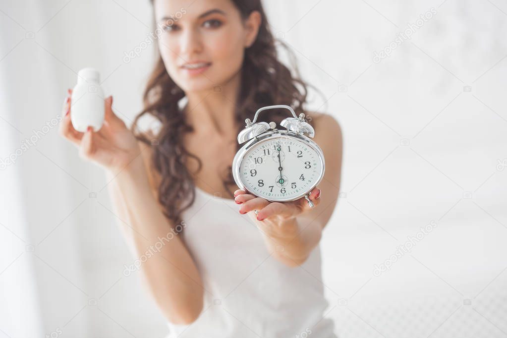 Young attractive woman taking pills at right time