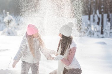 Genç Anne ve kızı karda eğleniyor