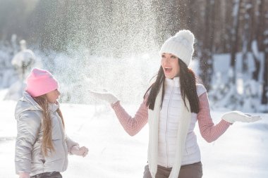 Genç Anne ve kızı karda eğleniyor