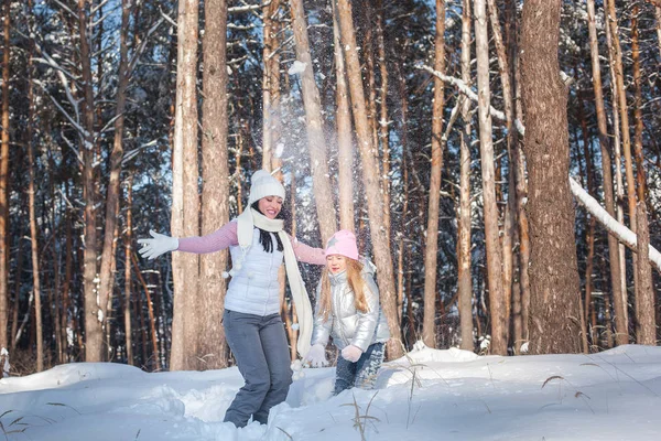 Genç güzel anne ve küçük kızı kışın dışarıda eğleniyor. Çocuk ve kar, doğa ile oynarken annesi güzel. Parçalı