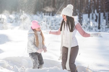 Genç güzel anne ve küçük kızı kışın dışarıda eğleniyor. Çocuk ve kar, doğa ile oynarken annesi güzel. Parçalı