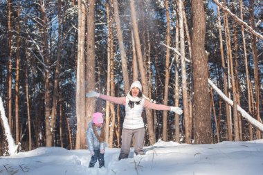 Genç güzel anne ve küçük kızı kışın dışarıda eğleniyor. Çocuk ve kar, doğa ile oynarken annesi güzel. Parçalı