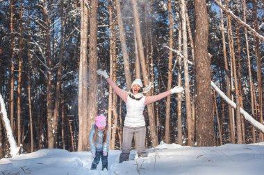 Genç güzel anne ve küçük kızı kışın dışarıda eğleniyor. Çocuk ve kar, doğa ile oynarken annesi güzel. Parçalı