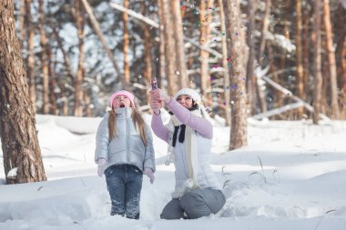 Genç Anne ve açık havada birlikte eğleniyor şirin küçük kızı çok. Cherful aile Noel kutlamaları.
