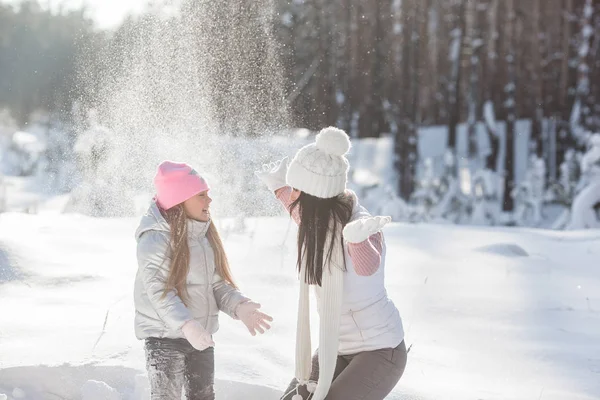 Genç güzel anne ve küçük kızı kışın dışarıda eğleniyor. Çocuk ve kar, doğa ile oynarken annesi güzel. Parçalı