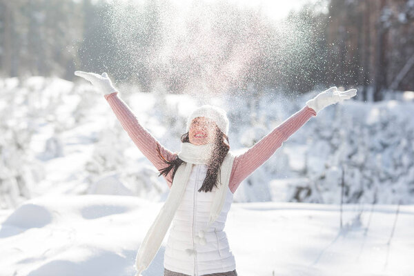 Cheerful young woman in winter time outdoors having fun