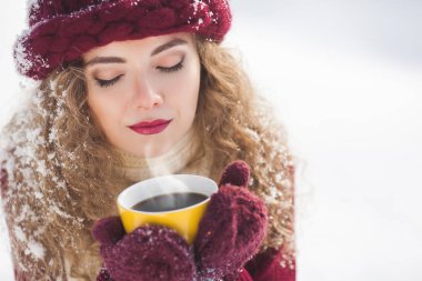 Genç güzel kadın portresi fincan sıcak kahve ile kapatmak