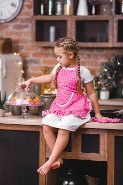 Küçük şirin kız mutfakta kek yeme