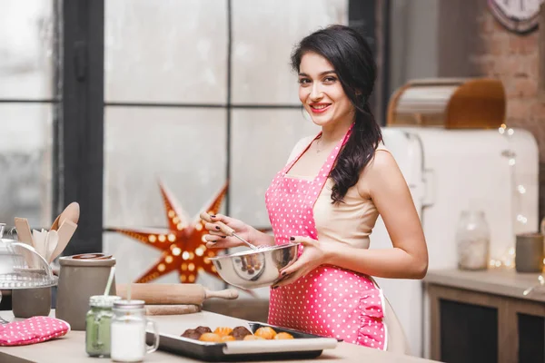 Young attractive woman baking in kitchen at home