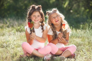 Sevimli küçük kız arkadaşlar açık havada birlikte eğleniyor,