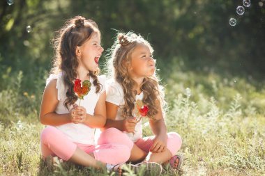 Sevimli küçük kız arkadaşlar açık havada birlikte eğleniyor,
