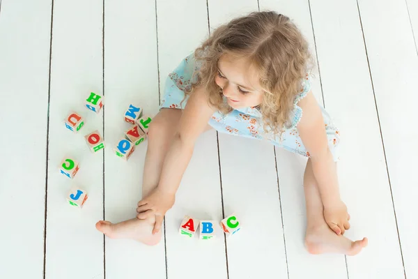 Gadis Kecil Yang Lucu Bermain Dengan Kubus Abc Dalam Ruangan — Stok Foto