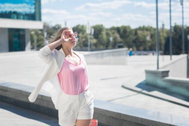 Açık havada beyaz takım giyen genç çekici kadın. Şık Bayan casual ceketli