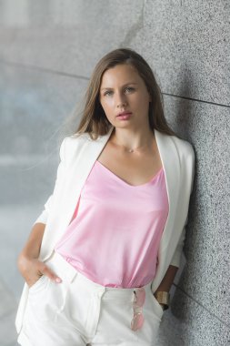 Açık havada beyaz takım giyen genç çekici kadın portresi kapatın. Şık Bayan casual ceketli