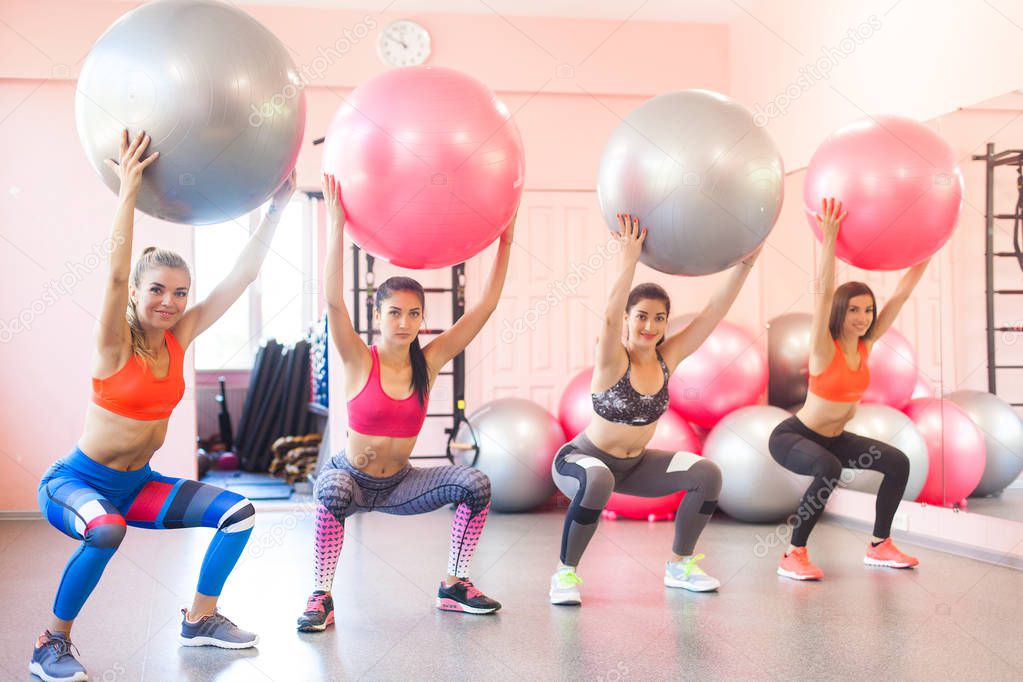 Group of young women doing exercises with fitballs. Pair exercises for fitness