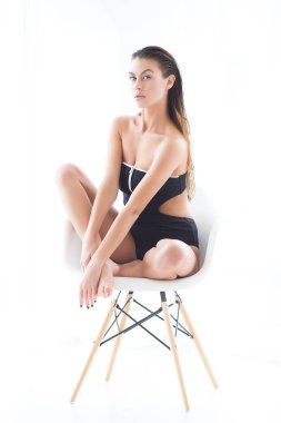 Tarafsız bir geçmişi olan çekici genç bir kadın. Sandalyede oturan güzel bir manken. Bayan moda portresi.