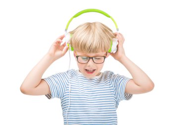Kulaklık müzik dinlerken beyaz sevimli çocuk üzerinde izole. Çocuk kulaklık beyaz zemin üzerine.