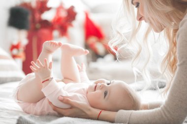 Genç çekici kaygı-in küçük bebek kızı anne. Güzel anne ve kızı yatak odasında kapalı. Sevgi dolu aile. Çekici anne çocuğunu tutan.