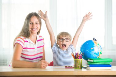 Şirin çocuk annesi ile bir ders öğrenme. Aile birlikte ödev. Bir görevi gerçekleştirmek onun küçük öğrenci açıklayan Mothe.