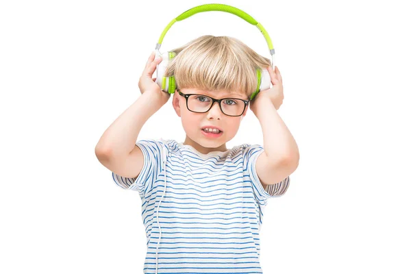 かわいい子は イヤホンやヘッドフォンを身に着けている非常に騒々しい音楽を聴きます 不幸な子供が ラジオを聞いている白い背景に分離 — ストック写真