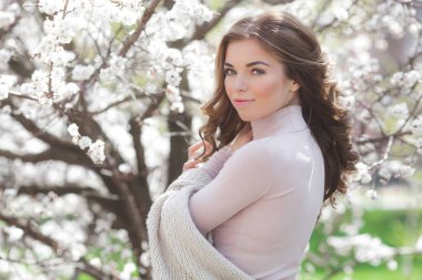 Çiçeklerle arka planda genç ve çekici bir kadın. Güzel bir kızın yakın portresi. Bahçedeki bayan.