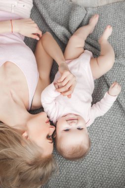 Genç çekici kaygı-in küçük bebek kızı anne. Güzel anne ve kızı yatak odasında kapalı. Sevgi dolu aile. Çekici anne çocuğunu tutan.