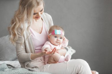 Genç çekici kaygı-in küçük bebek kızı anne. Güzel anne ve kızı yatak odasında kapalı. Sevgi dolu aile. Çekici anne çocuğunu tutan.