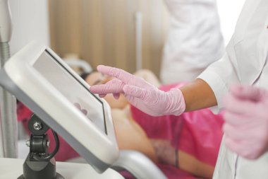 Tıbbi ekipman yazarak doktor eller. Tanınmayan doktor. Hala lateks eldiven giymiş el kadar yakın. Lazer epilasyon işlemi yaparken güzellik uzmanı